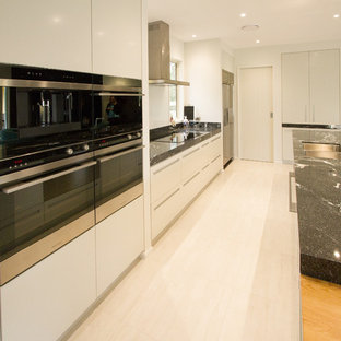 Mid-sized contemporary kitchen pantry inspiration - Example of a mid-sized trendy galley ceramic floor kitchen pantry design in Napier-Hastings with a double-bowl sink, white cabinets, granite countertops, white backsplash, glass sheet backsplash, stainless steel appliances and an island