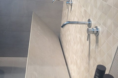 Immagine di una piccola stanza da bagno con doccia minimal con doccia a filo pavimento, piastrelle beige, piastrelle in gres porcellanato, pareti beige, pavimento in gres porcellanato, lavabo sospeso e pavimento grigio