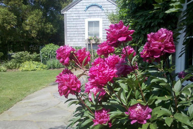 Inspiration for a mid-sized traditional full sun backyard stone retaining wall landscape in Boston.