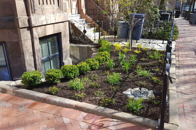 This is an example of a small traditional full sun front yard brick formal garden in Boston.
