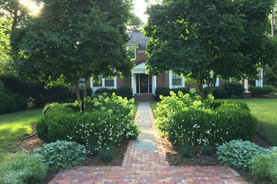 This is an example of a mid-sized traditional full sun front yard brick walkway in Other.