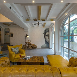 Mediterranes Wohnzimmer mit weißer Wandfarbe, Betonboden und grauem Boden in Mumbai