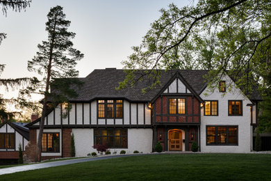 Large traditional white four-story stucco exterior home idea in Kansas City with a shingle roof and a gray roof