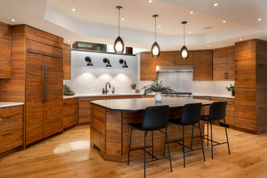 Open concept kitchen - mid-sized contemporary u-shaped light wood floor and coffered ceiling open concept kitchen idea in Portland with flat-panel cabinets, medium tone wood cabinets, quartz countertops, white backsplash, quartz backsplash, stainless steel appliances, an island and white countertops