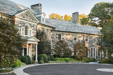 Example of a huge classic three-story stone house exterior design in New York with a shingle roof