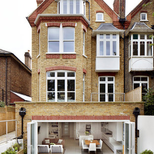 Idées déco pour une façade en brique classique à deux étages et plus avec un toit à deux pans.