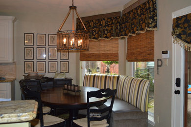 Eat-in kitchen - mid-sized l-shaped slate floor eat-in kitchen idea in Houston with a farmhouse sink, white cabinets, granite countertops, beige backsplash, stone tile backsplash, paneled appliances, an island and raised-panel cabinets
