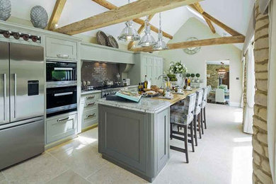 Inspiration for a large farmhouse single-wall enclosed kitchen with a belfast sink, shaker cabinets, green cabinets, granite worktops, metallic splashback, porcelain splashback, stainless steel appliances, limestone flooring and an island.