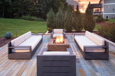 Photo of a mid-sized contemporary backyard patio in Minneapolis with a fire feature, concrete pavers and no cover.