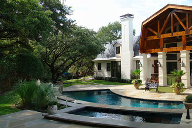 Transitional backyard stone and custom-shaped pool photo in Dallas
