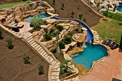 Large trendy backyard custom-shaped natural water slide photo in Austin with decking