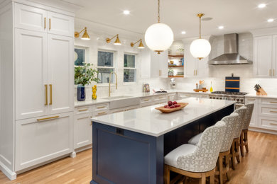 Eat-in kitchen - large modern medium tone wood floor eat-in kitchen idea in New York with an integrated sink, white cabinets, marble countertops, white backsplash, an island and white countertops