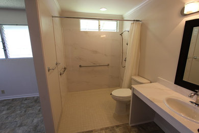 This is an example of a mid-sized traditional master bathroom in Hawaii with raised-panel cabinets, white cabinets, a two-piece toilet, beige tile, brown tile, gray tile, ceramic tile, white walls, ceramic floors, a drop-in sink and engineered quartz benchtops.