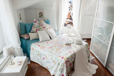 Foto di una camera da letto contemporanea con pareti bianche e pavimento in legno massello medio