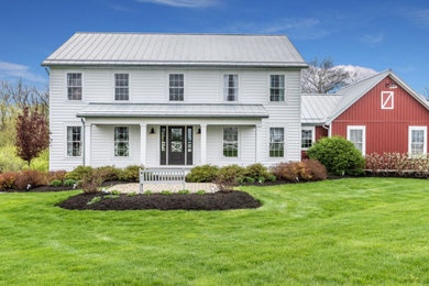 Cottage white two-story vinyl house exterior idea in Columbus with a metal roof