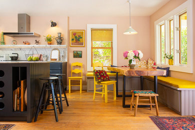 Eat-in kitchen - mid-sized craftsman u-shaped medium tone wood floor eat-in kitchen idea in Los Angeles with a farmhouse sink, shaker cabinets, blue cabinets, marble countertops, white backsplash, marble backsplash, stainless steel appliances, an island and white countertops