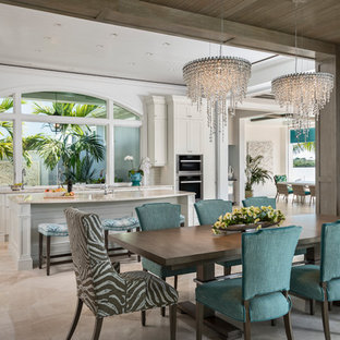 Cette photo montre une grande salle à manger ouverte sur la cuisine chic avec un mur marron, aucune cheminée, un sol beige et un sol en travertin.