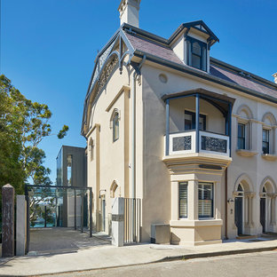 Свежая идея для дизайна: большой, трехэтажный фасад таунхауса бежевого цвета в современном стиле с черепичной крышей - отличное фото интерьера