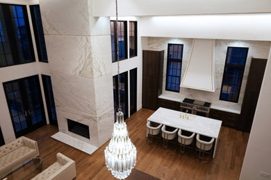 Example of a minimalist medium tone wood floor kitchen design in Other with marble countertops, marble backsplash and an island