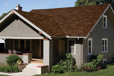 Modelo de fachada de casa gris y marrón tradicional con tejado de teja de madera