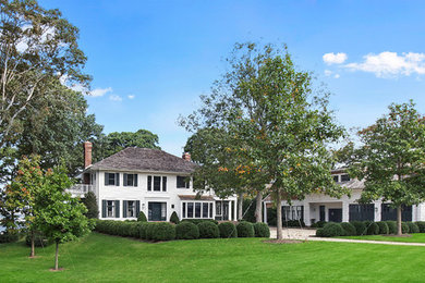 Large traditional two-storey white house exterior in Philadelphia with wood siding, a hip roof and a shingle roof.