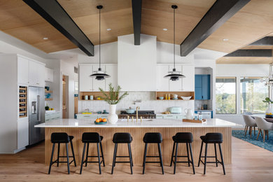 Mid-sized 1960s single-wall medium tone wood floor and beige floor eat-in kitchen photo in San Francisco with an undermount sink, shaker cabinets, white cabinets, quartz countertops, beige backsplash, stainless steel appliances, an island and white countertops