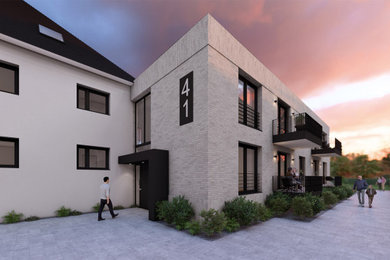 Modernes Haus mit Mix-Fassade, beiger Fassadenfarbe, Flachdach und schwarzem Dach in Sonstige
