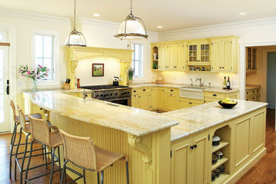 Huge u-shaped vinyl floor and brown floor eat-in kitchen photo in Other with a farmhouse sink, flat-panel cabinets, yellow cabinets, granite countertops, white backsplash, stone tile backsplash, stainless steel appliances, a peninsula and yellow countertops