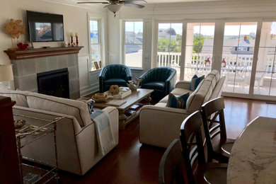 Large beach style open concept medium tone wood floor family room photo in Philadelphia with white walls, a standard fireplace, a stone fireplace and a wall-mounted tv