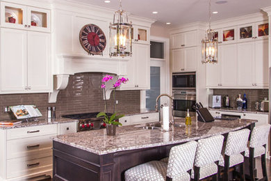 Elegant dark wood floor and brown floor eat-in kitchen photo with an integrated sink, white cabinets, granite countertops, gray backsplash, stainless steel appliances, an island and multicolored countertops