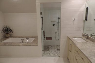 Photo of a mid-sized transitional master bathroom in Raleigh with shaker cabinets, beige cabinets, an undermount tub, a curbless shower, a two-piece toilet, white tile, ceramic tile, white walls, ceramic floors, an undermount sink, quartzite benchtops, white floor and a hinged shower door.