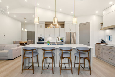 Example of a country light wood floor kitchen design in Other with stainless steel appliances, an island and white countertops