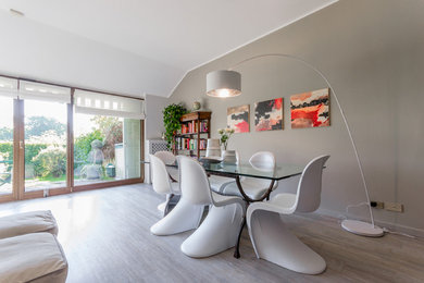 Photo of a large modern separate dining room in Milan with grey walls, vinyl floors, a standard fireplace and grey floor.