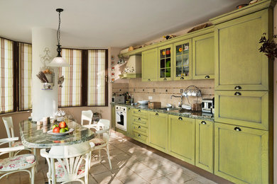Kitchen - mid-sized cottage u-shaped terra-cotta tile kitchen idea in Other with an integrated sink, green cabinets, granite countertops, beige backsplash, stone slab backsplash, colored appliances and a peninsula