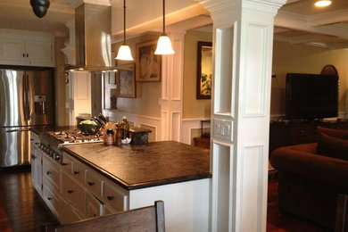 Inspiration for a mid-sized transitional l-shaped medium tone wood floor eat-in kitchen remodel in San Francisco with recessed-panel cabinets, white cabinets, granite countertops, stainless steel appliances and an island