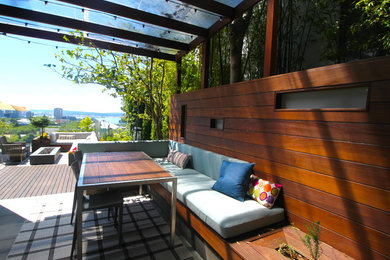 Large contemporary rooftop deck in Seattle with a roof extension and a fire feature.