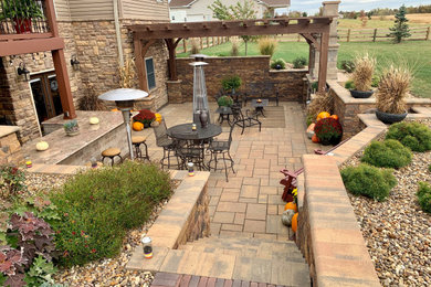 Design ideas for a large contemporary full sun backyard concrete paver retaining wall landscape in Columbus.
