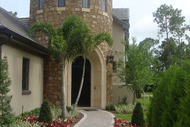 This is an example of a large mediterranean two-storey beige exterior in Orlando with mixed siding.