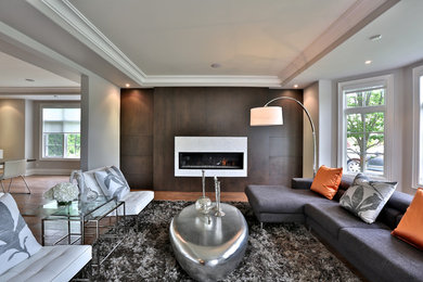 Living room - contemporary dark wood floor living room idea in Toronto with gray walls, no fireplace and a wood fireplace surround