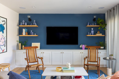 Offenes Modernes Wohnzimmer mit blauer Wandfarbe, hellem Holzboden und TV-Wand in Los Angeles