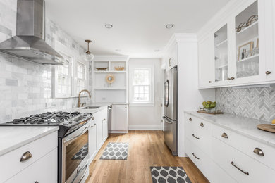 Design ideas for a transitional galley separate kitchen in Indianapolis with an undermount sink, flat-panel cabinets, white cabinets, white splashback, marble splashback, stainless steel appliances, medium hardwood floors, no island and brown floor.