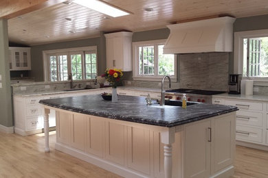 Inspiration for a large rustic u-shaped light wood floor open concept kitchen remodel in Denver with an undermount sink, shaker cabinets, white cabinets, granite countertops, gray backsplash, stone slab backsplash, stainless steel appliances and an island