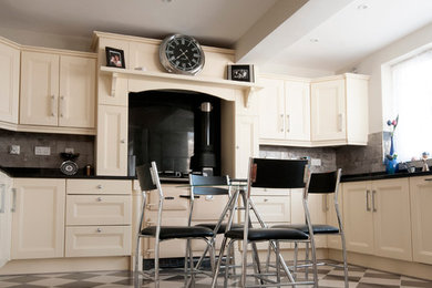Photo of a mid-sized country kitchen in Dublin with grey splashback, stone tile splashback and porcelain floors.