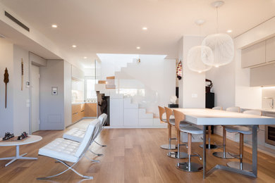 Esempio di un piccolo soggiorno minimal aperto con pareti grigie, pavimento in legno verniciato, parete attrezzata e soffitto ribassato