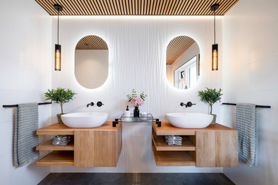 Идея дизайна: большая главная ванная комната: освещение в современном стиле с открытыми фасадами, светлыми деревянными фасадами, отдельно стоящей ванной, открытым душем, унитазом-моноблоком, белой плиткой, керамической плиткой, белыми стенами, полом из керамической плитки, серым полом, открытым душем, тумбой под две раковины, подвесной тумбой и потолком из вагонки