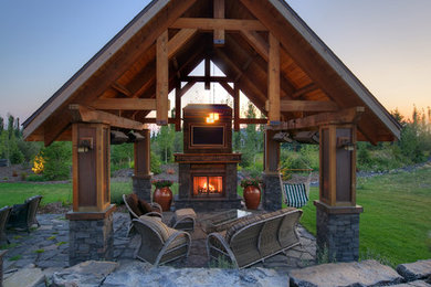 This is an example of a mid-sized traditional backyard patio in Calgary with a fire feature and a pergola.