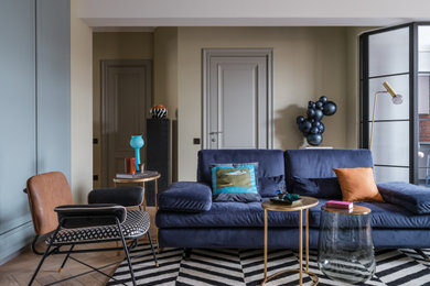 Foto di un soggiorno design di medie dimensioni con libreria, pareti verdi, parquet chiaro, TV a parete, pavimento beige e pareti in mattoni
