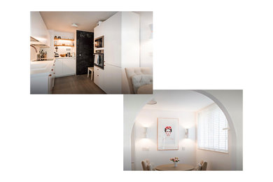 Eat-in kitchen - mid-sized contemporary u-shaped ceramic tile and brown floor eat-in kitchen idea in London with flat-panel cabinets, solid surface countertops, white backsplash, ceramic backsplash, black appliances and white countertops
