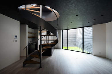 На фото: большая винтовая лестница в стиле модернизм с деревянными ступенями, металлическими перилами и обоями на стенах без подступенок