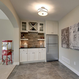 ミネアポリスの大きいトランジショナルスタイルのおしゃれなウェットバー (アンダーカウンターシンク、落し込みパネル扉のキャビネット、白いキャビネット、茶色いキッチンパネル、磁器タイルのキッチンパネル) の写真